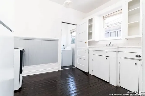 a view of a kitchen with wooden floor and electronic appliances
