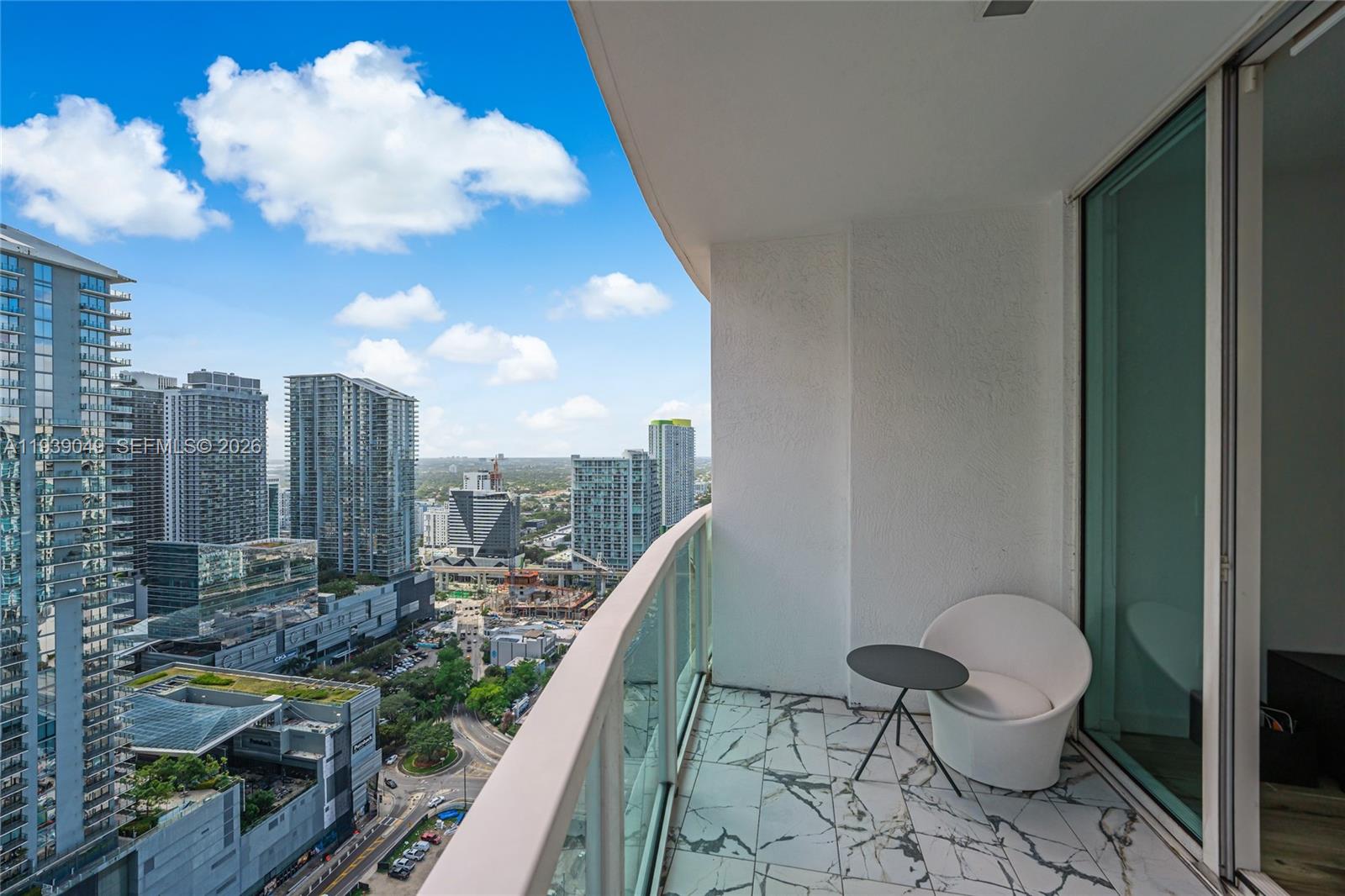 31 Southeast 5th Street, Unit 3918 Miami, FL 33131 - Photo 19 of 24 a view of a balcony with two chairs and a potted plant