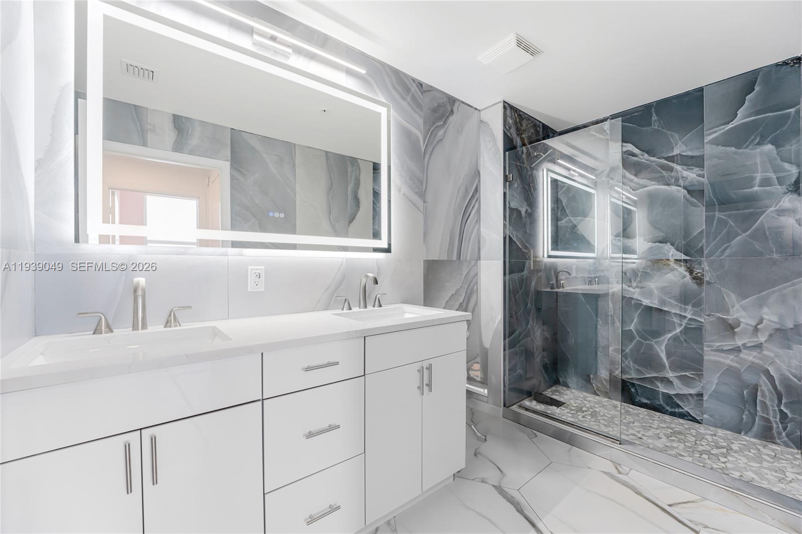 31 Southeast 5th Street, Unit 3918 Miami, FL 33131 - Photo 10 of 24 a bathroom with a sink and a mirror