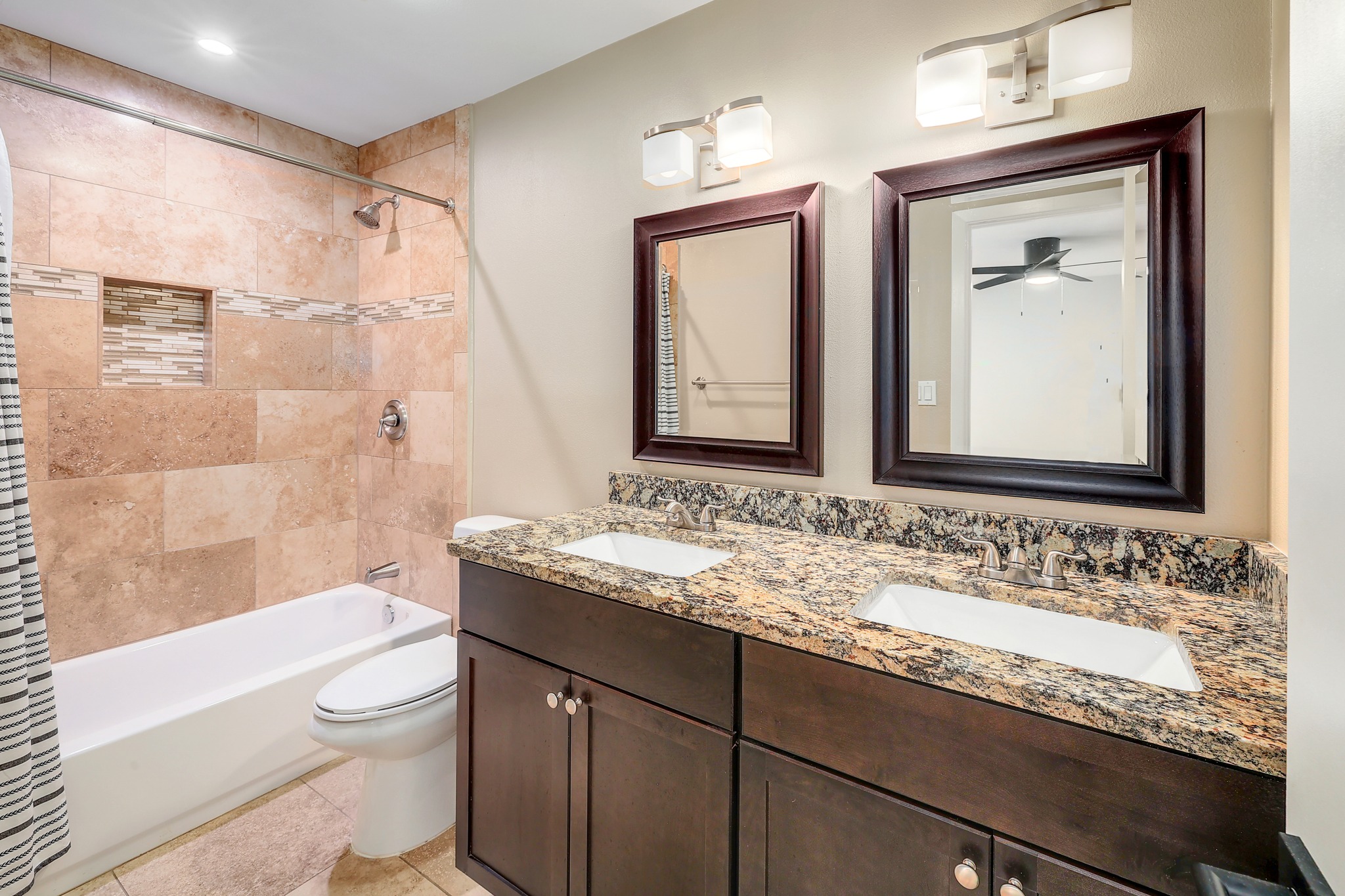 9614 Chukar Circle Austin, TX 78758 - Photo 18 of 26 The second primary ensuite bath is also updated with timeless finishes including a granite countertop, rich cabinetry, and a shower/tub combo with tiled backsplash.