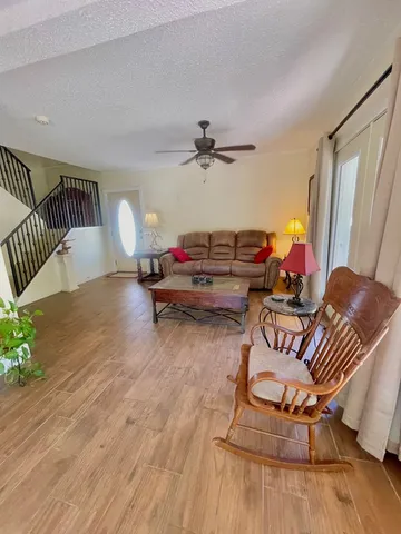 a living room with furniture and a wooden floor