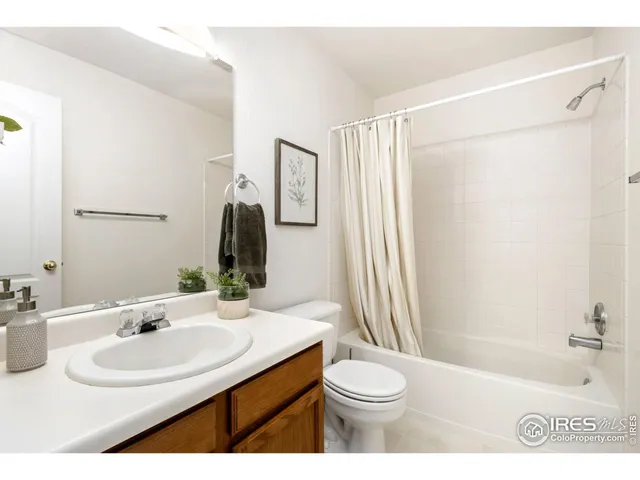 a bathroom with a sink a toilet a mirror and shower