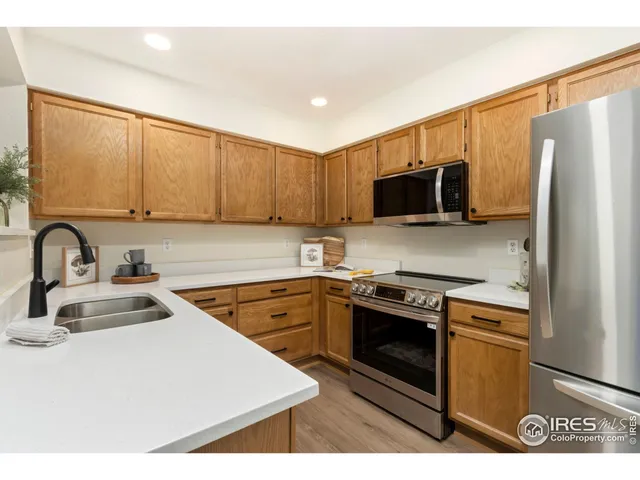 a kitchen with stainless steel appliances granite countertop a stove a sink dishwasher and a refrigerator