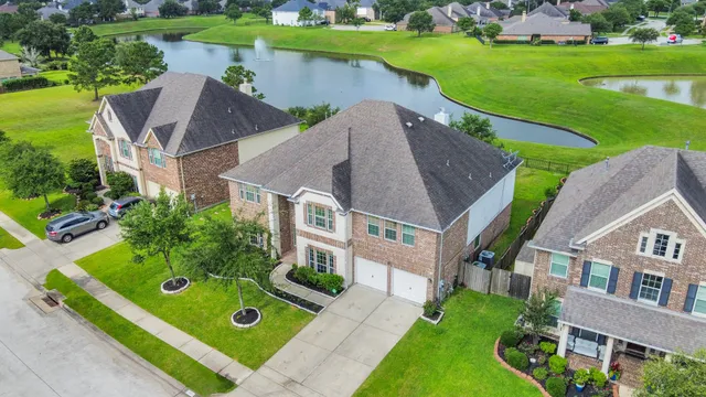 an aerial view of a house with a garden and lake view