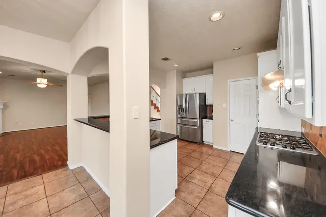 a kitchen with stainless steel appliances granite countertop a refrigerator and a stove top oven
