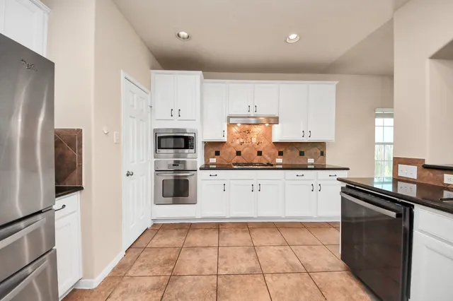 a kitchen with stainless steel appliances a refrigerator sink and microwave