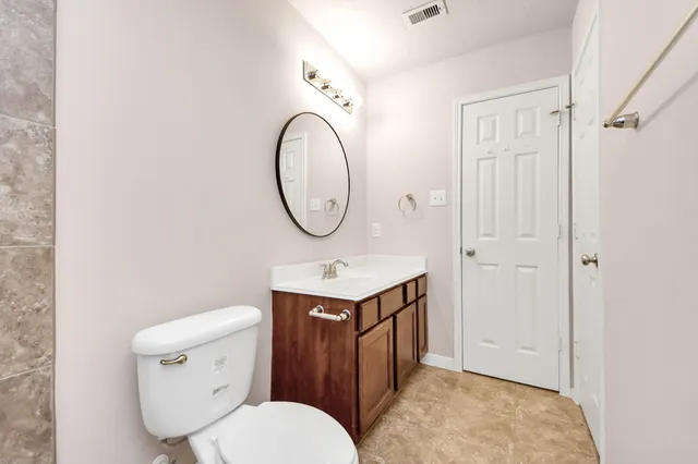 a bathroom with a toilet a sink and a mirror