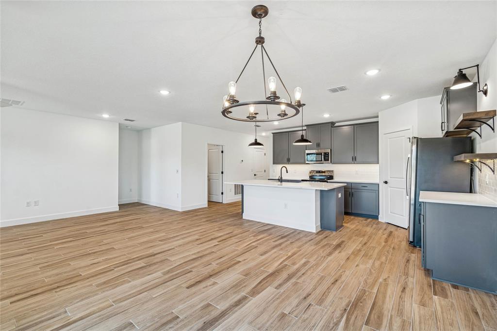 3617 Southwest 153rd Pl Road, Unit 6 Ocala, FL 34473 - Photo 15 of 31 a large kitchen with kitchen island a sink dishwasher a refrigerator and wooden floor