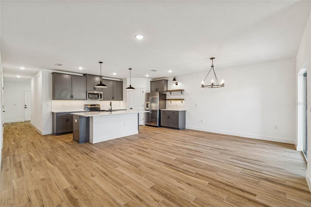 3617 Southwest 153rd Pl Road, Unit 6 Ocala, FL 34473 - Photo 17 of 31 a large kitchen with stainless steel appliances kitchen island a large counter top and wooden floors