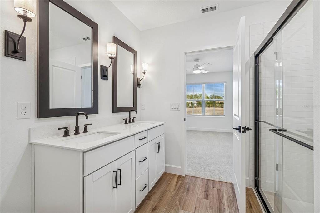 3617 Southwest 153rd Pl Road, Unit 6 Ocala, FL 34473 - Photo 27 of 31 a bathroom with a double vanity sink a mirror and a shower