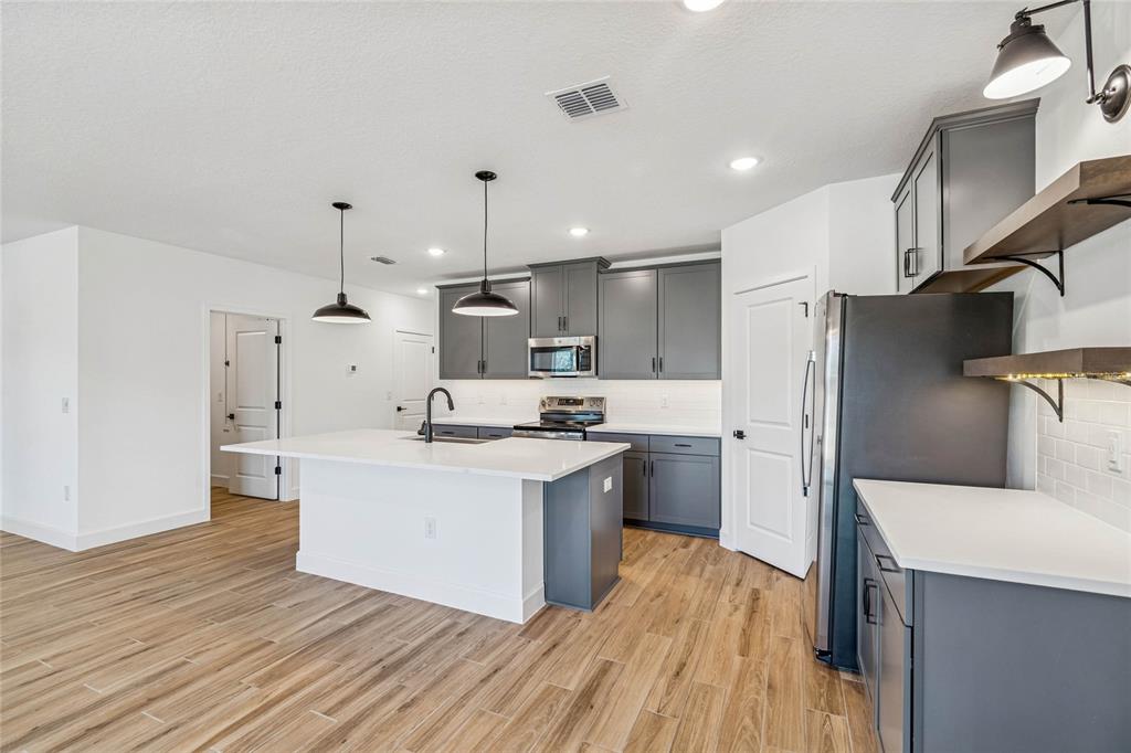 3617 Southwest 153rd Pl Road, Unit 6 Ocala, FL 34473 - Photo 10 of 31 a kitchen with a sink a refrigerator and wooden floor