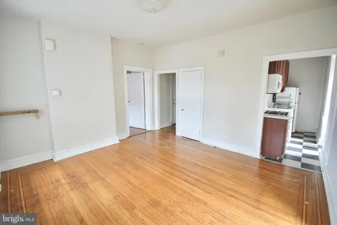 a view of empty room with wooden floor