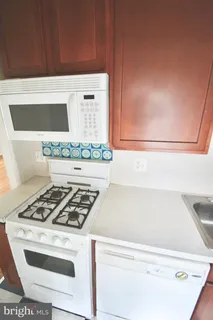 a white stove top oven sitting inside of a kitchen
