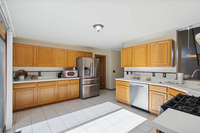 a kitchen with stainless steel appliances a sink window and cabinets