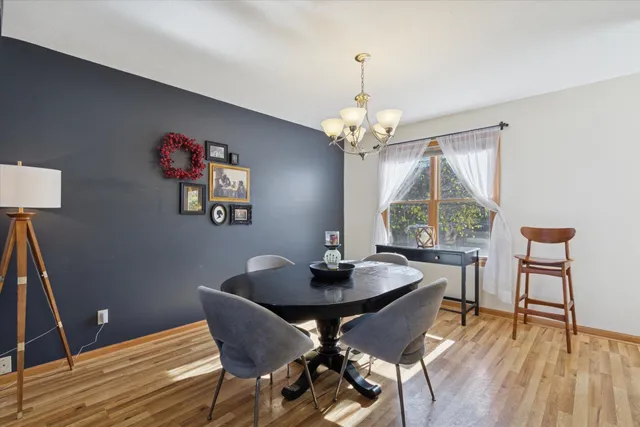 a dining room with furniture a chandelier and wooden floor