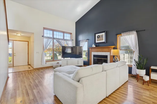 a living room with fireplace furniture and a large window