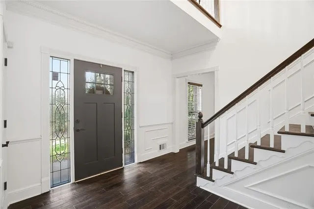 a view of staircase with wooden floor and white walls