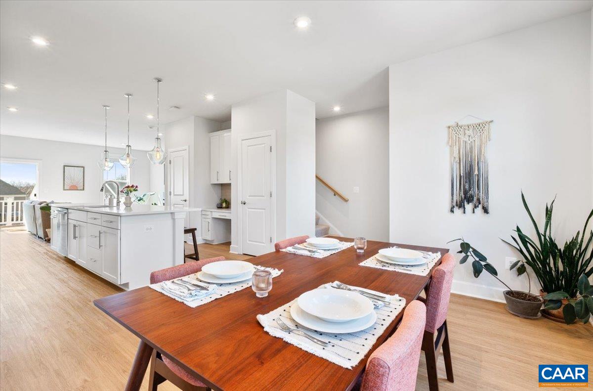 5963 McComb Street Crozet, VA 22932 - Photo 29 of 65 a open dining room with stainless steel appliances kitchen island a table chairs and a refrigerator