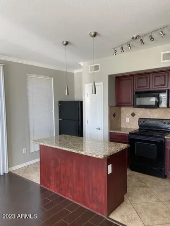 a kitchen with kitchen island granite countertop a stove and a refrigerator