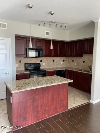 a large kitchen with stainless steel appliances granite countertop a stove a sink dishwasher and a refrigerator