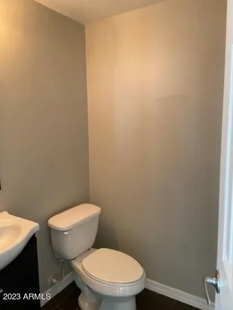 a white toilet sitting next to a white wall