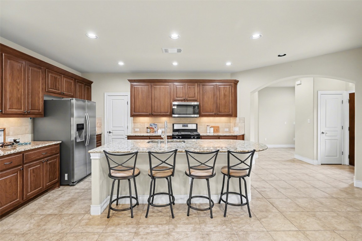 116 Trailing Lantana Drive, Unit G Georgetown, TX 78628 - Photo 11 of 38 a kitchen with stainless steel appliances granite countertop a stove a sink a dining table and chairs