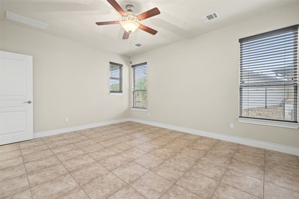 116 Trailing Lantana Drive, Unit G Georgetown, TX 78628 - Photo 19 of 38 an empty room with windows and fan
