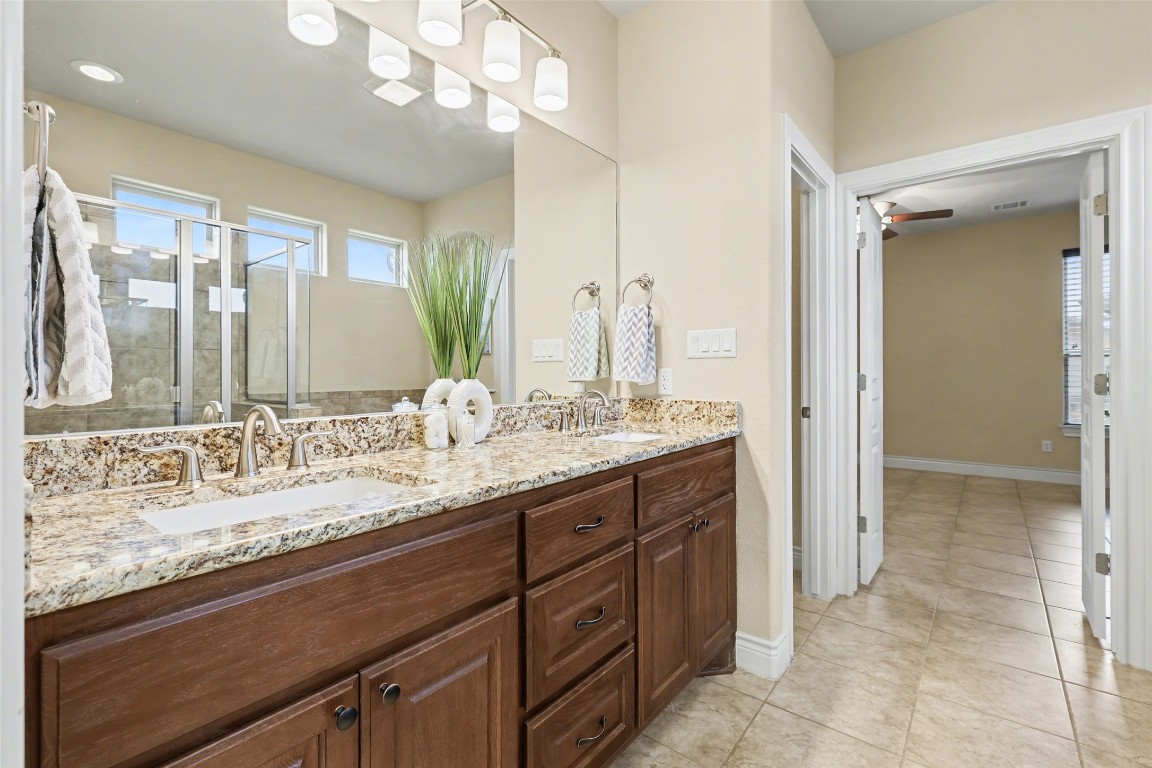 116 Trailing Lantana Drive, Unit G Georgetown, TX 78628 - Photo 28 of 38 a bathroom with a granite countertop sink a large mirror and a shower