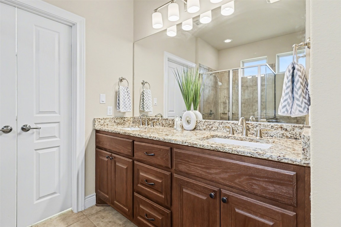 116 Trailing Lantana Drive, Unit G Georgetown, TX 78628 - Photo 29 of 38 a bathroom with a granite countertop sink and a mirror