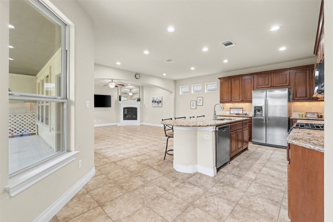 116 Trailing Lantana Drive, Unit G Georgetown, TX 78628 - Photo 8 of 38 a kitchen with stainless steel appliances kitchen island granite countertop a refrigerator and a stove top oven