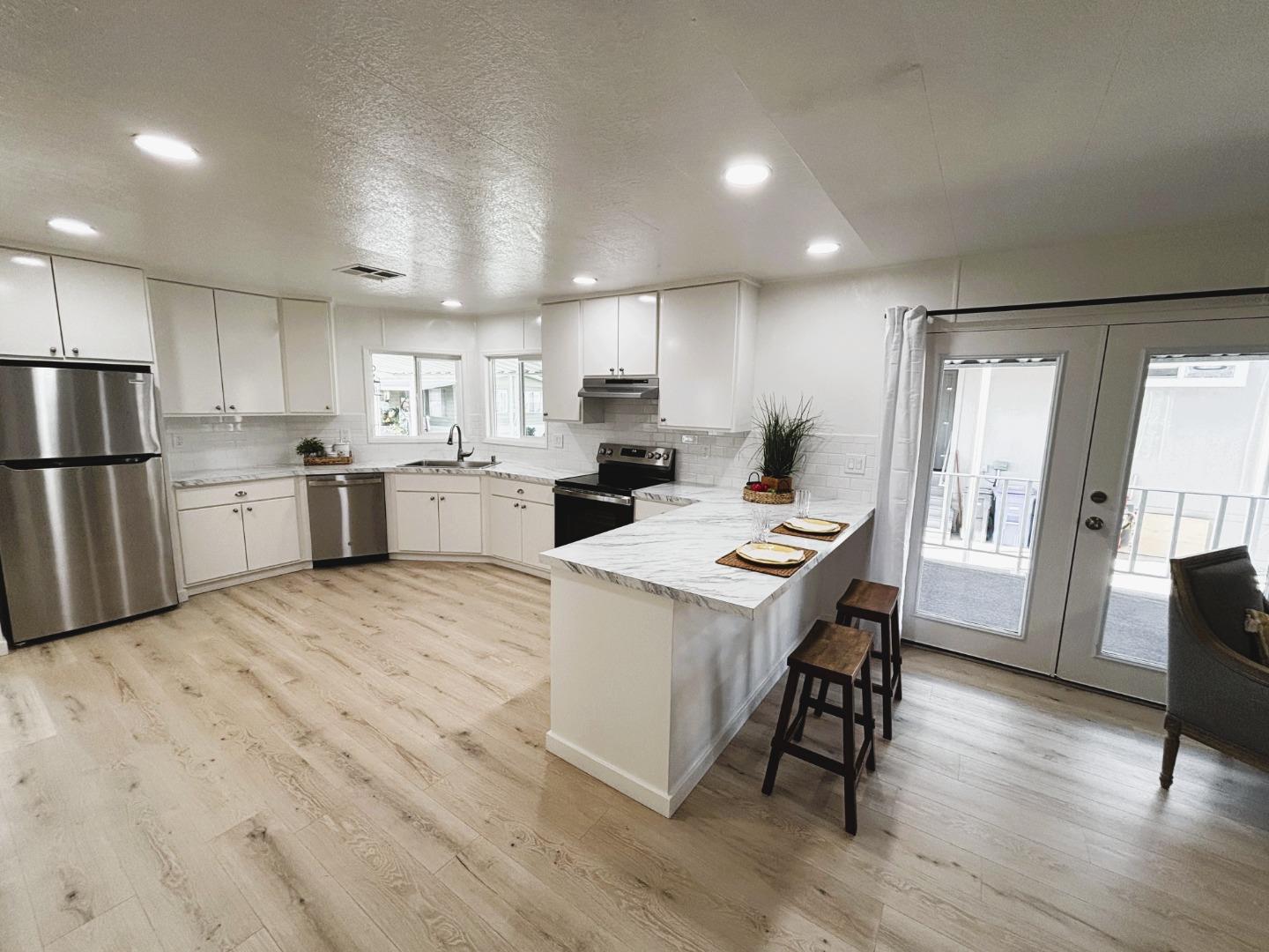 a kitchen with refrigerator and wooden floor
