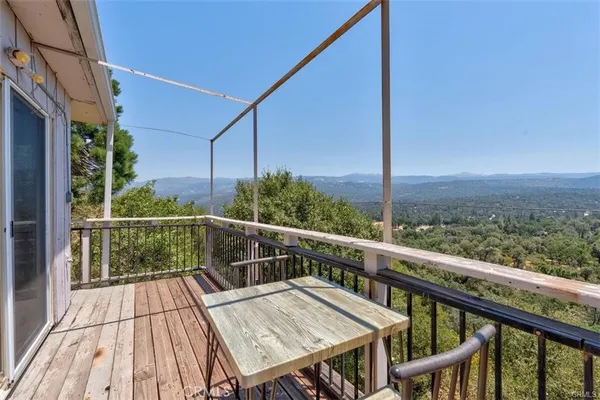 a view of a balcony with wooden floor and iron stairs