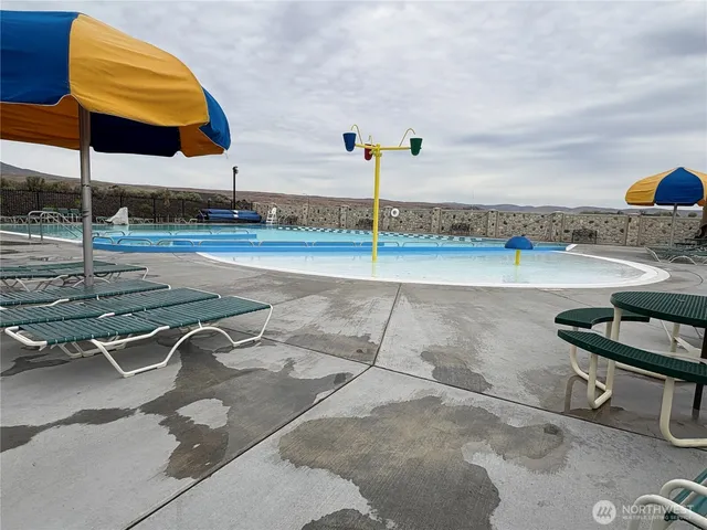 a view of a swimming pool with a chair and tables