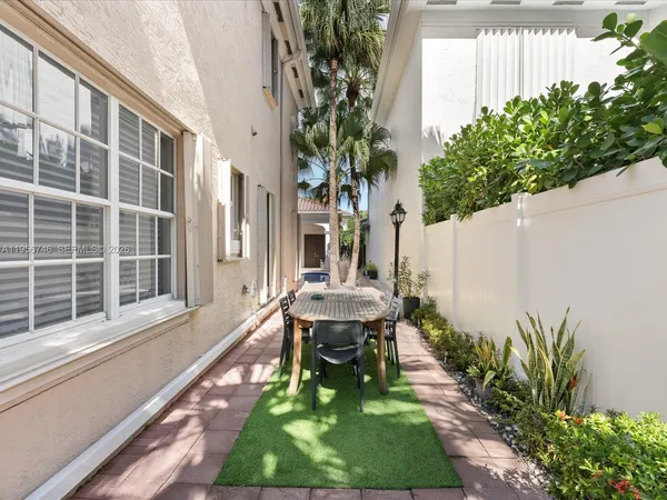 a view of a pathway with house potted plants in front of door
