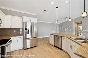 a kitchen with stainless steel appliances granite countertop a refrigerator a sink and a stove