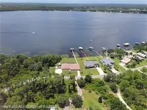 an aerial view of a house with a yard and lake view
