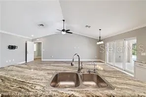 a kitchen with stainless steel appliances kitchen island granite countertop a stove top oven a sink dishwasher and a refrigerator with wooden floor