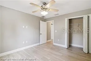 a view of an empty room with a chandelier fan