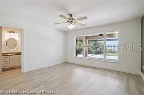 an empty room with windows and fan