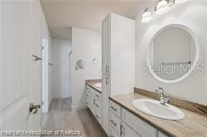 a spacious bathroom with a granite countertop sink mirror and a shower