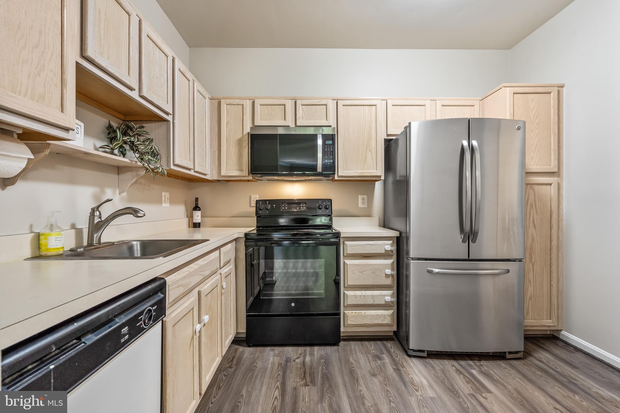 11408 Gate Hill Place, Unit 113 Reston, VA 20194 - Photo 16 of 30 a kitchen with a refrigerator stove and a sink