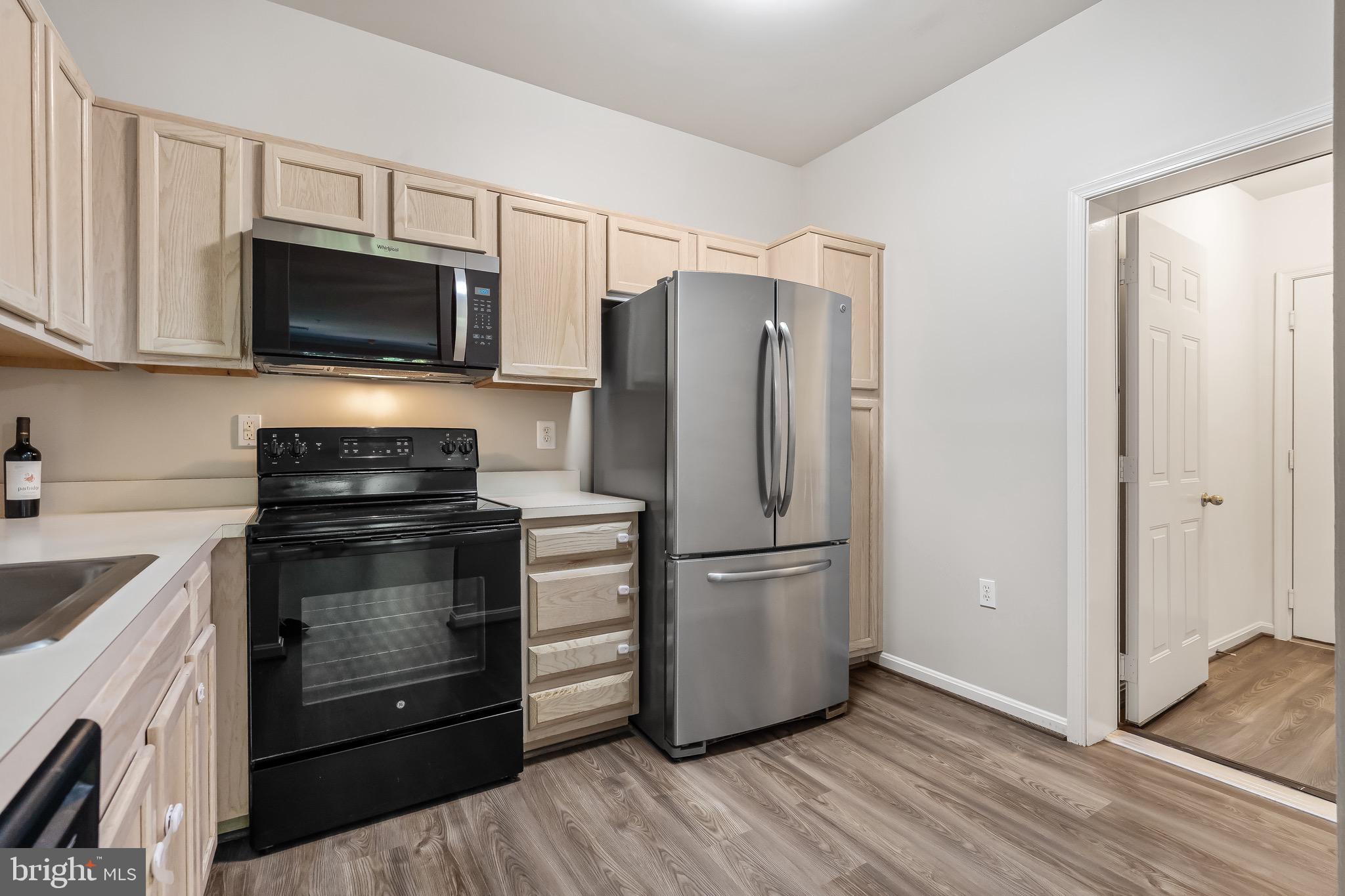 11408 Gate Hill Place, Unit 113 Reston, VA 20194 - Photo 17 of 30 a kitchen with granite countertop a refrigerator stove and microwave