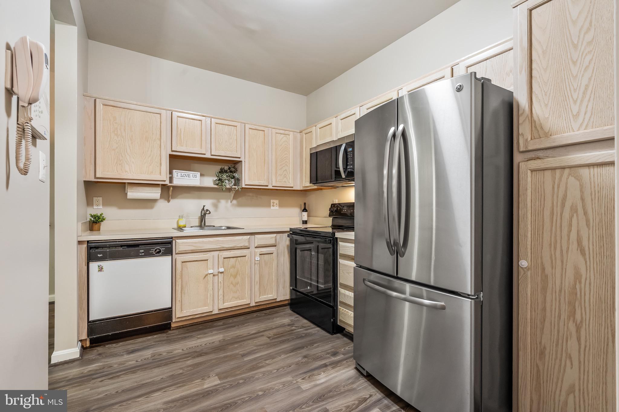 11408 Gate Hill Place, Unit 113 Reston, VA 20194 - Photo 18 of 30 a kitchen with stainless steel appliances a refrigerator sink and cabinets