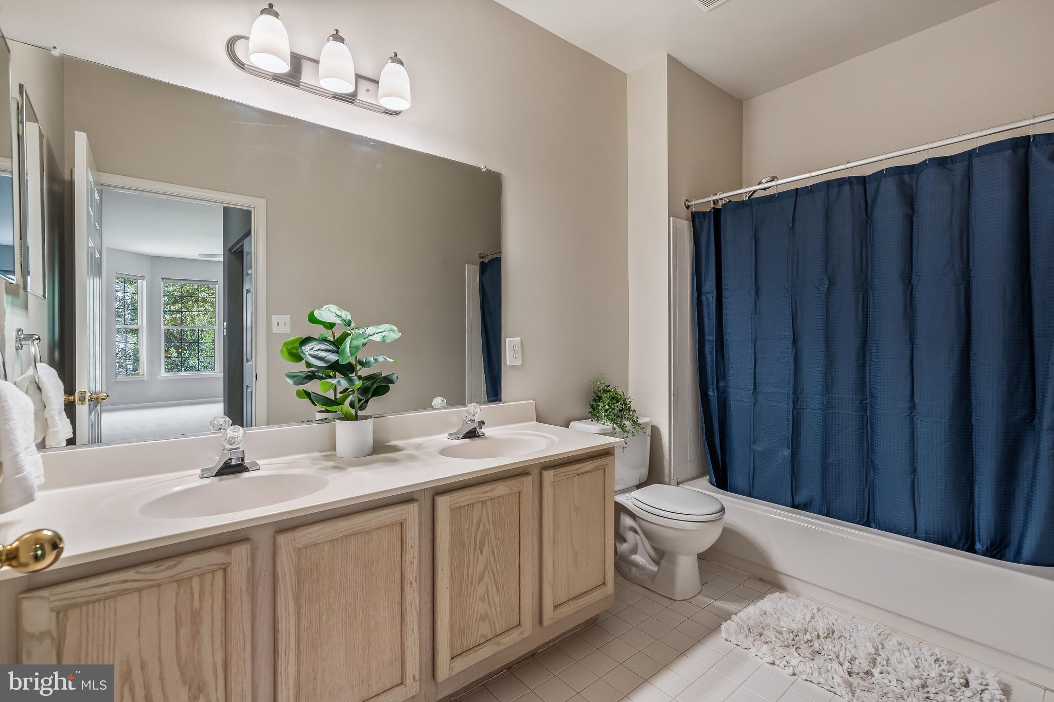 11408 Gate Hill Place, Unit 113 Reston, VA 20194 - Photo 25 of 30 a bathroom with a granite countertop sink vanity mirror and toilet