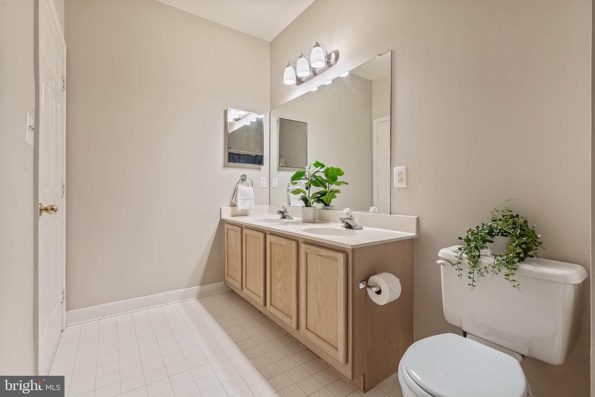 11408 Gate Hill Place, Unit 113 Reston, VA 20194 - Photo 27 of 30 a bathroom with a sink vanity mirror and toilet