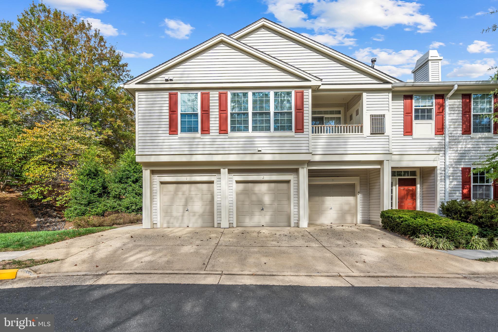 11408 Gate Hill Place, Unit 113 Reston, VA 20194 - Photo 4 of 30 a front view of a house with a yard and a garage