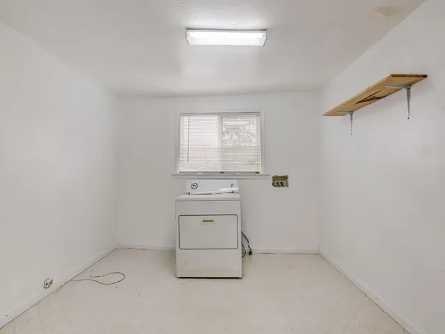 an empty room with a stove and a window
