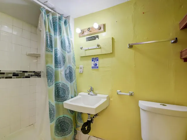 a bathroom with a sink a toilet and a mirror