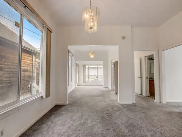 a view of a big room with windows and chandelier