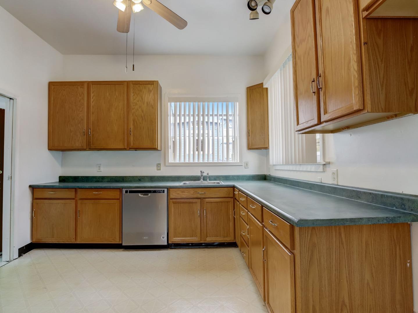 1164 Ocean Avenue Oakland, CA 94608 - Photo 7 of 32 a kitchen with stainless steel appliances granite countertop a sink and a stove